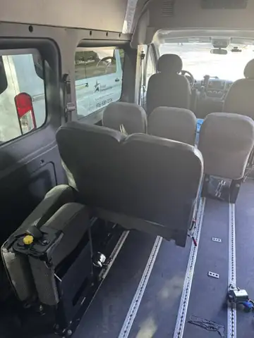 Inside a Westar van: rows of passenger seats, with metal tracks in the floor for securing a wheelchair.